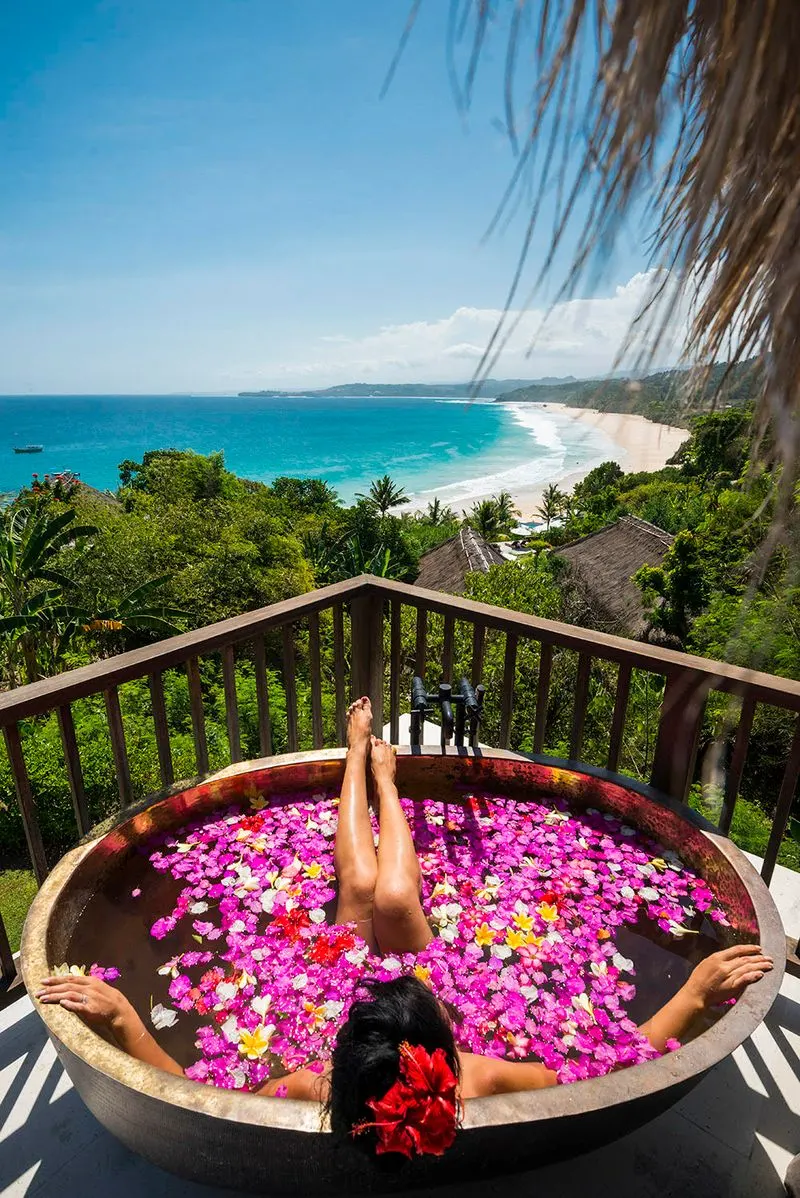 Flower-filled soaking tub on the patio with view over Nihiwatu Beach