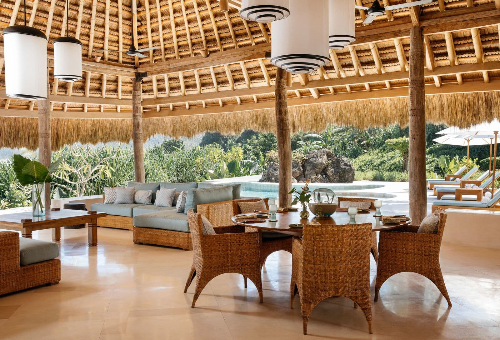 Open-air thatched pavilion lounge with pool and ocean beyond