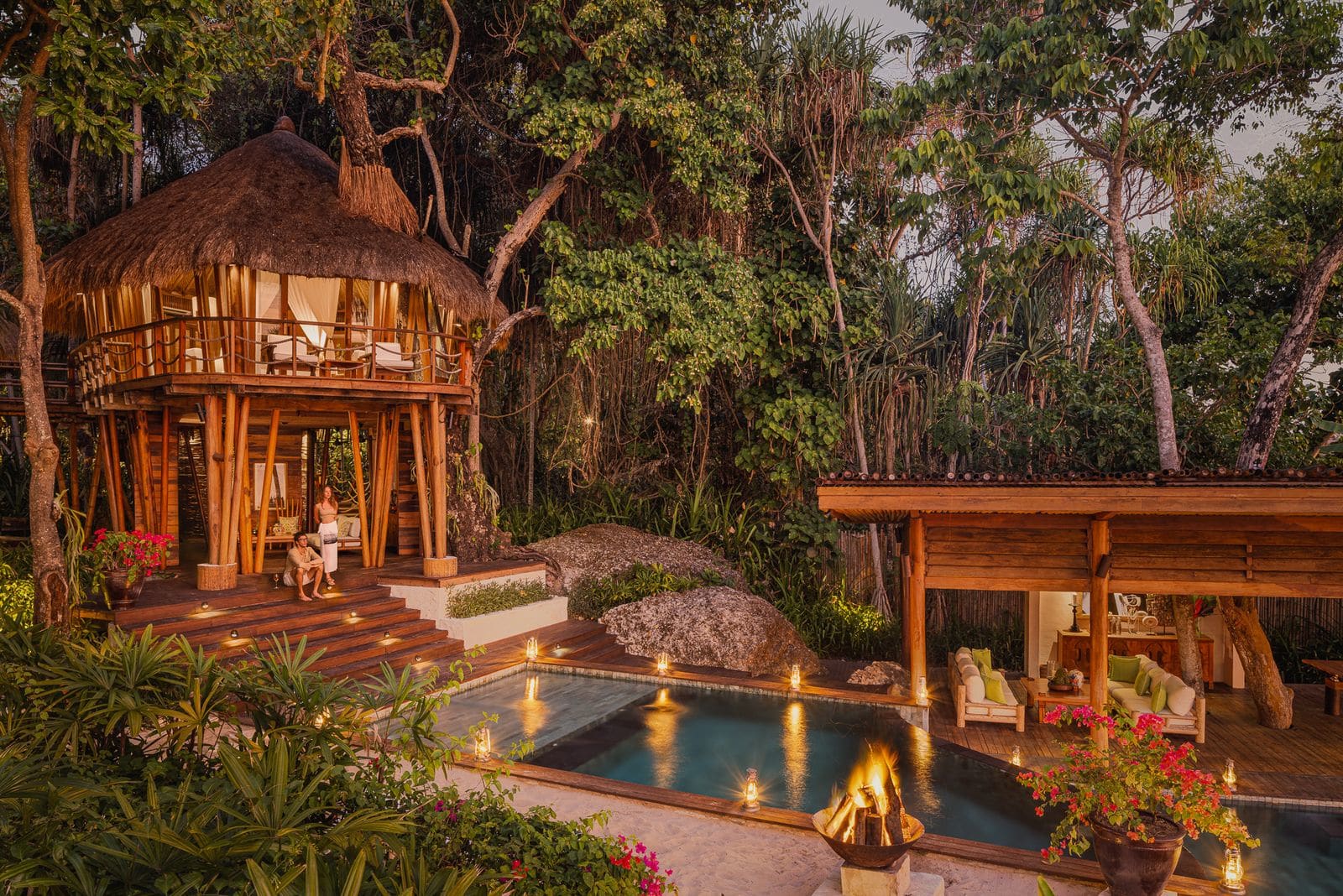 Firelit treehouse villa at dusk