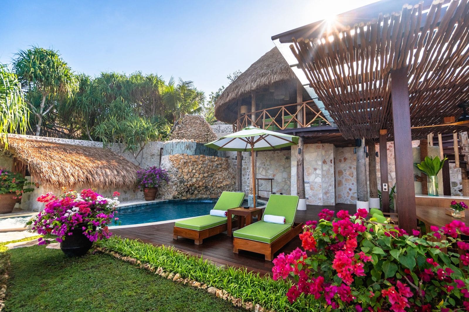 Private villa pool with bougainvillea and thatched pavilion