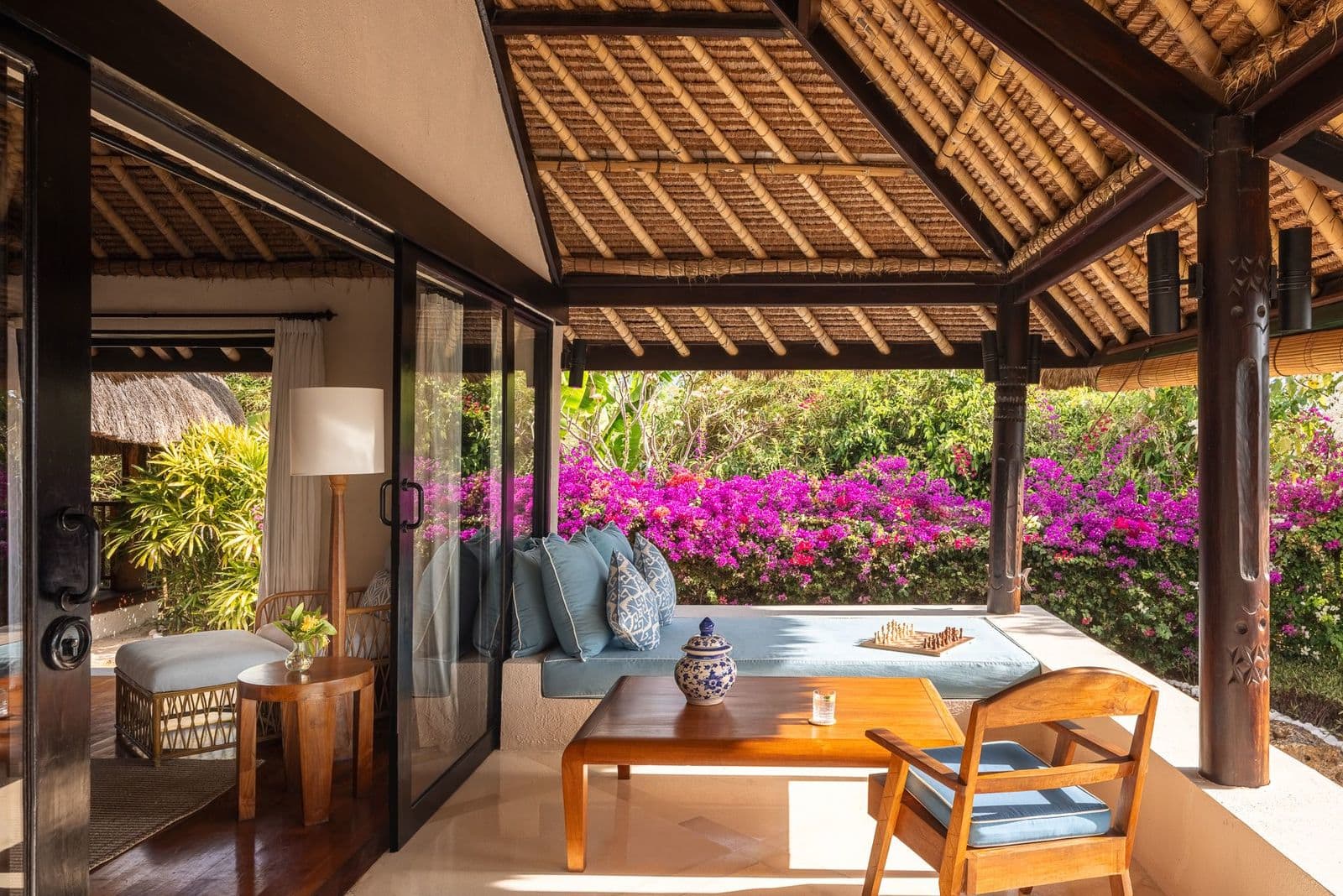 Shaded verandah daybed framed by bougainvillea blooms